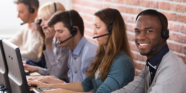 Customer service representatives on the computer and speaking on headsets